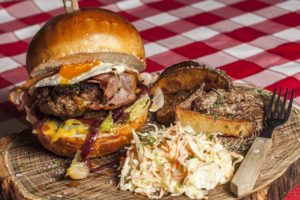 Huge burger with a side of cole slaw.