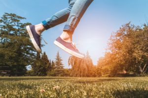 Woman jumping in the air in a park.